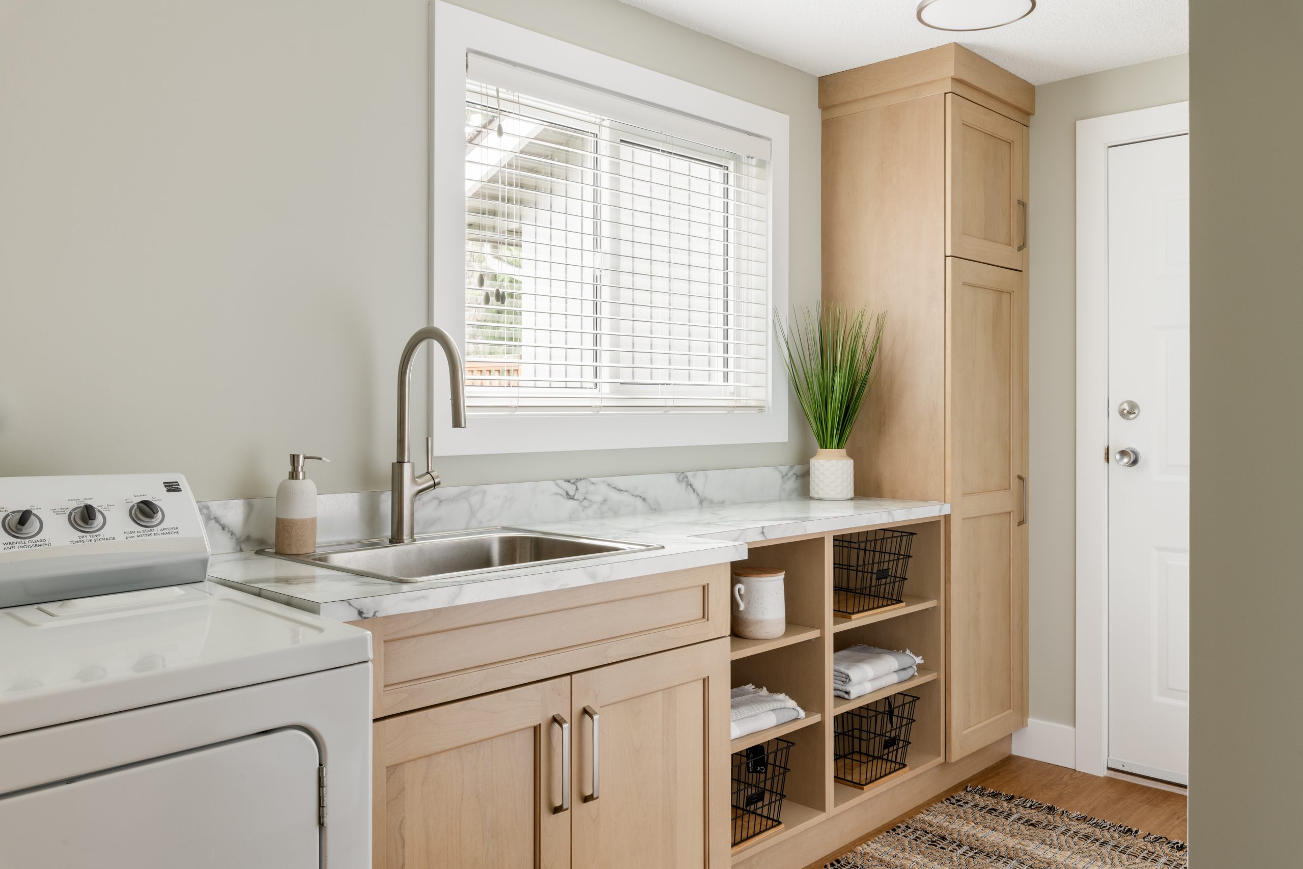 Custom laundry and utility room cabinetry with integrated storage and sink – part of a seamless kitchen renovation in Victoria BC.